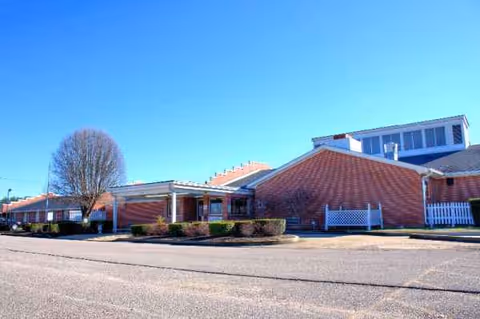 Exterior view of Adamsville Healthcare and Rehabilitation Center building under clear blue sky.