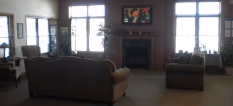 Cozy living room with sofas, a fireplace, and a wall-mounted TV.