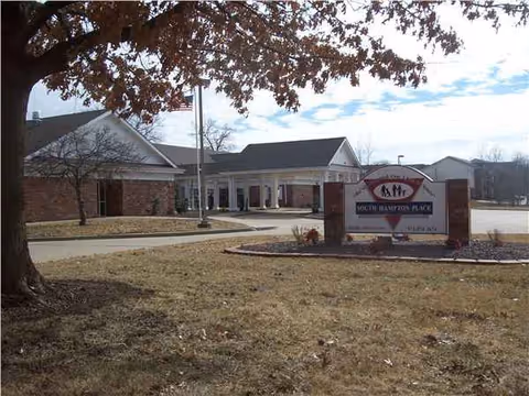 Exterior view of South Hampton Place Rehabilitation and Health Care Center with entrance and a sign.