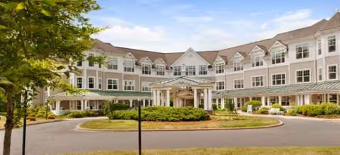 Exterior view of Brookdale West Hartford, a white multi-story facility with a circular driveway and entrance.