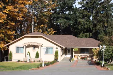 Single-story beige building with a brown roof and a paved front walkway.