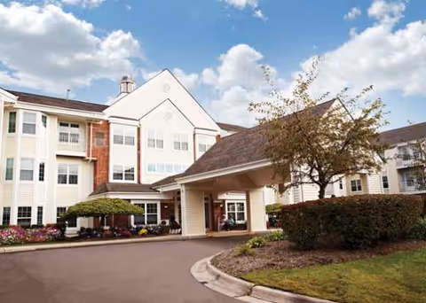 Exterior view of a Grand Rapids senior living facility with a covered entrance and manicured landscaping.