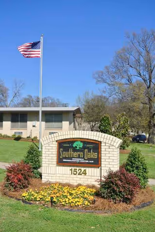 American flag near the Southern Oaks Nursing & Rehabilitation Center sign with landscaping