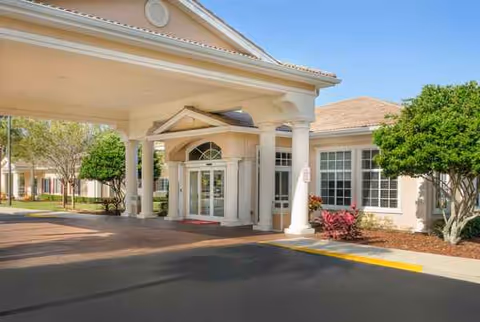 Entrance to a senior living facility featuring a porte-cochère and columned entry.