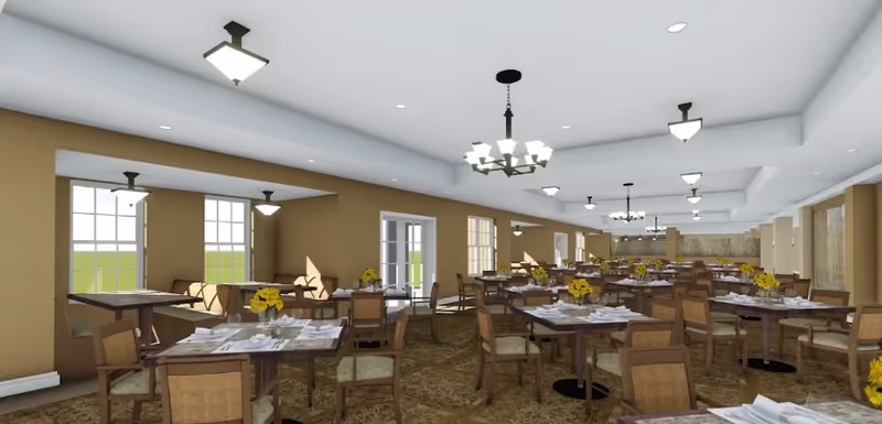 A spacious dining room with multiple tables and chairs arranged neatly. Each table is set with white plates, napkins, and silverware, and decorated with small yellow flower centerpieces. The room has beige walls, large windows allowing natural light, and ceiling lights including chandeliers and flush mounts. The carpet has a patterned design, and there is a door leading outside or to another room.