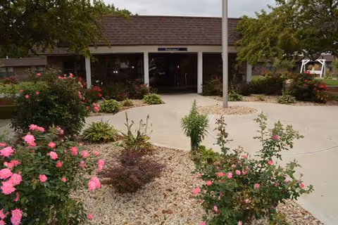 Front entrance of Valparaiso Care and Rehabilitation with landscaped flower beds.