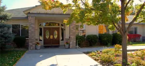 Edgewood Castle Hills entrance with double doors, brick columns, and landscaped shrubs.