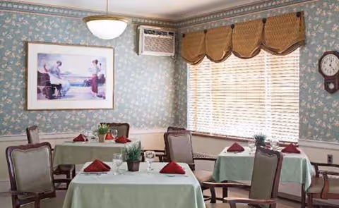 Dining room at Saugus Rehabilitation & Nursing Center with green tablecloths and red napkins.