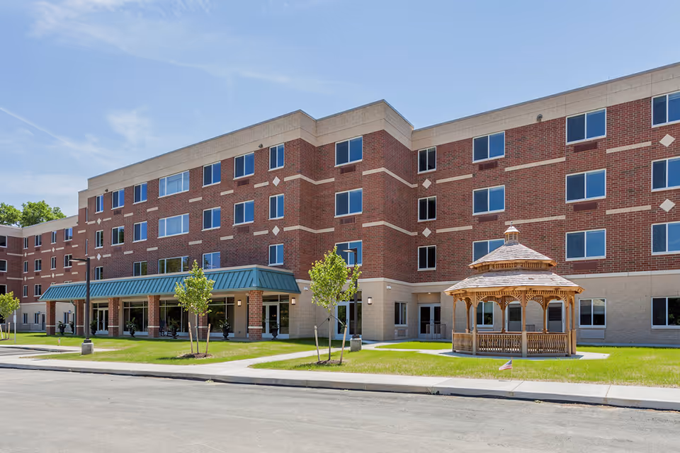 Exterior view of The Residence at Bethel Park, a brick senior living building with a gazebo.