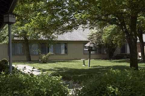 Front view of London Health and Rehab Center, a single-story building with lawn and trees.
