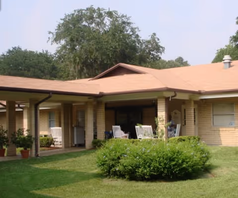 Front view of Camelot Chateau Assisted Living with a covered patio and lawn.