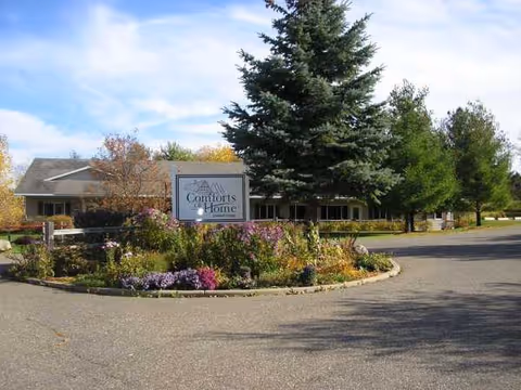 Exterior view of Comforts of Home St Croix II with sign, garden bed, and trees.