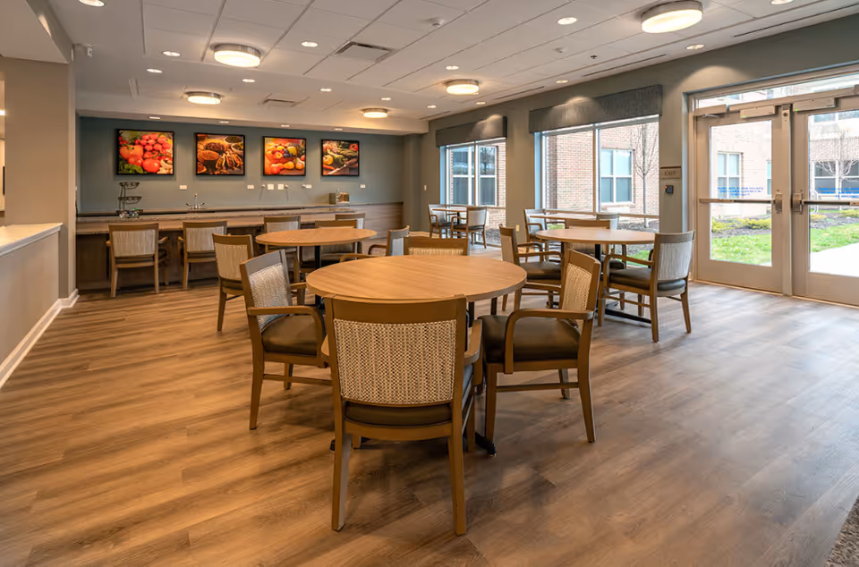 Spacious interior dining area with round tables, cushioned chairs, and a beverage counter.