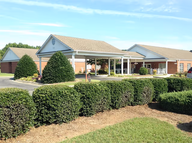 Meadowview senior living facility exterior with a covered entrance and manicured hedges.