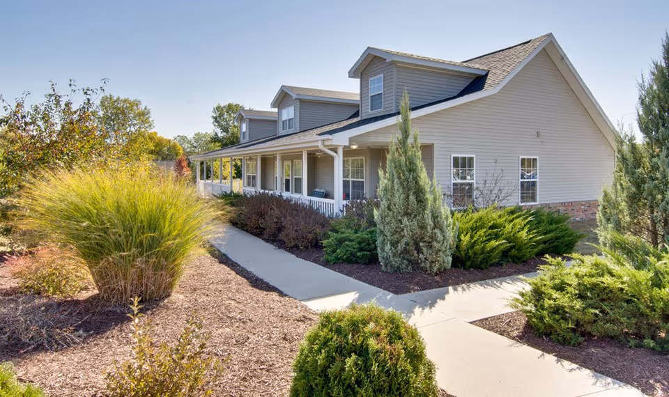 Front exterior view of Ravenwood Terrace with a landscaped walkway and shrubs.