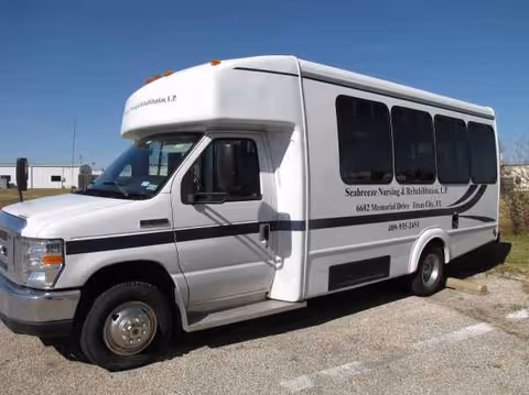 White Seabreeze Nursing and Rehabilitation shuttle bus parked outdoors with branding.