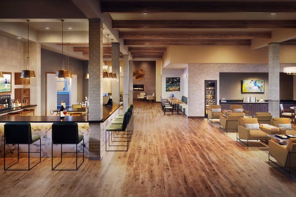 Spacious senior living common area with a marble-front bar, dining tables, and lounge seating under exposed wooden beams.