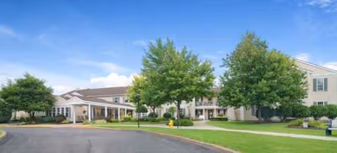 Exterior view of Brookdale Summerfield with entrance, trees, and green lawn.