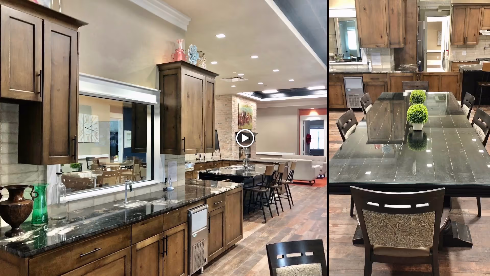 Interior view of a kitchen area with wooden cabinets, a dark granite countertop, and a sink. Adjacent to the kitchen is a dining table with chairs and small green decorative plants on top. The background shows a living area with seating and a wall painting.