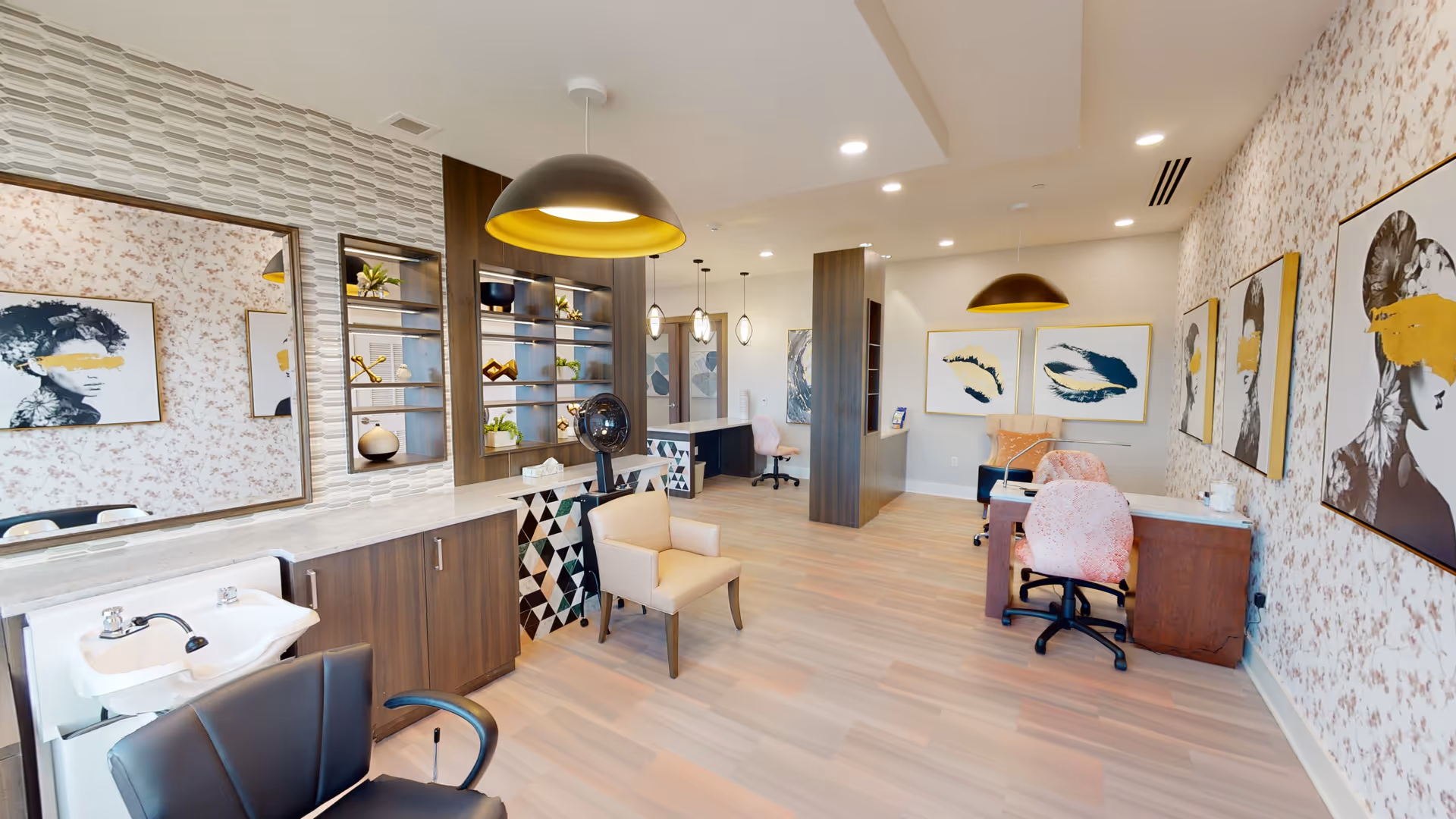 Spacious modern senior living salon with styling chairs, a wash basin, desks, shelving and framed artwork.