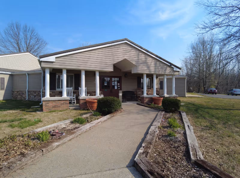 Single-story retirement community building with a covered front porch and walkway.