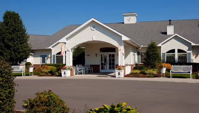 Exterior view of Walden Place senior living facility entrance with benches and shrubs.