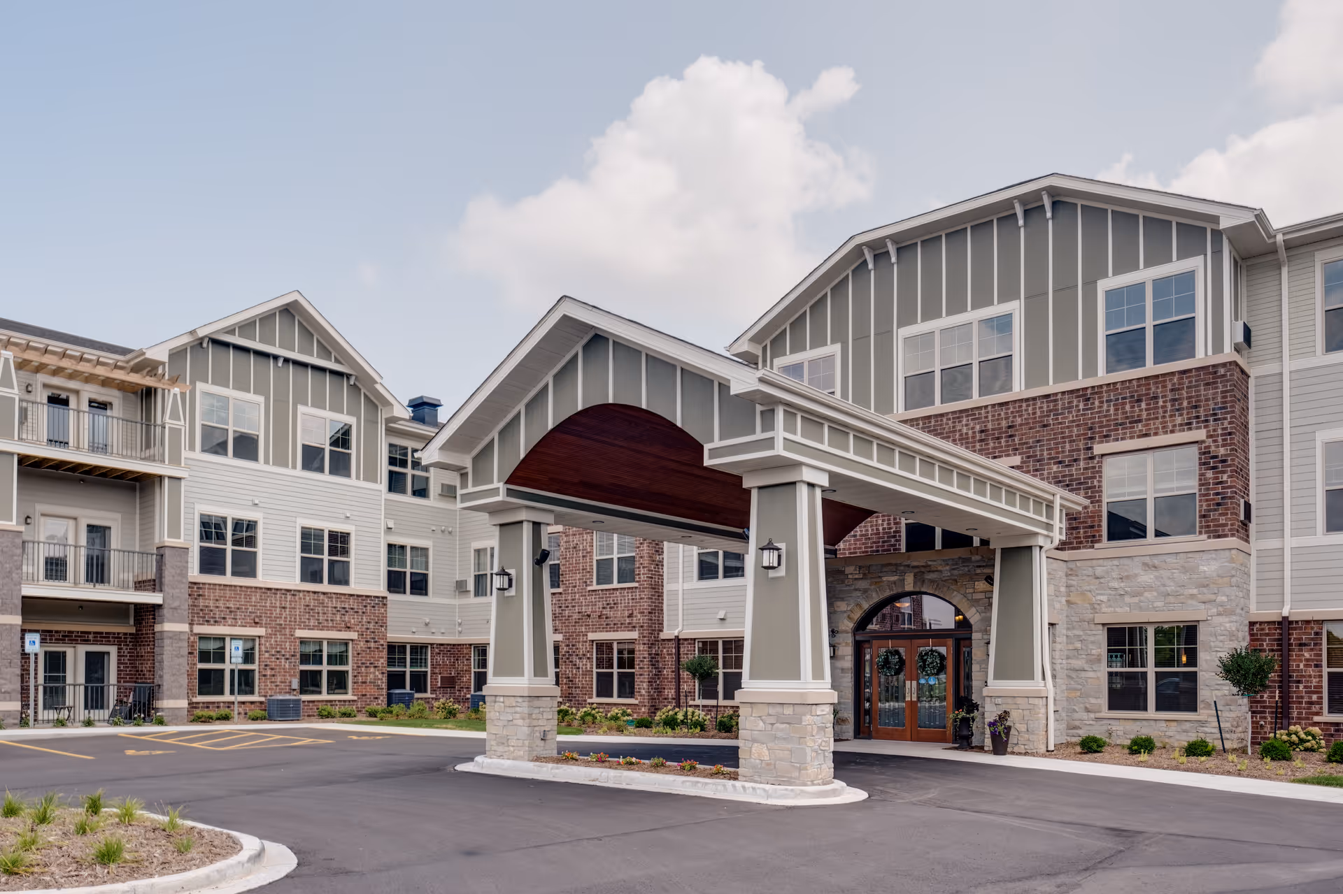 Exterior view of Aspire Senior Living Kimberly building with a covered entryway and parking lot.