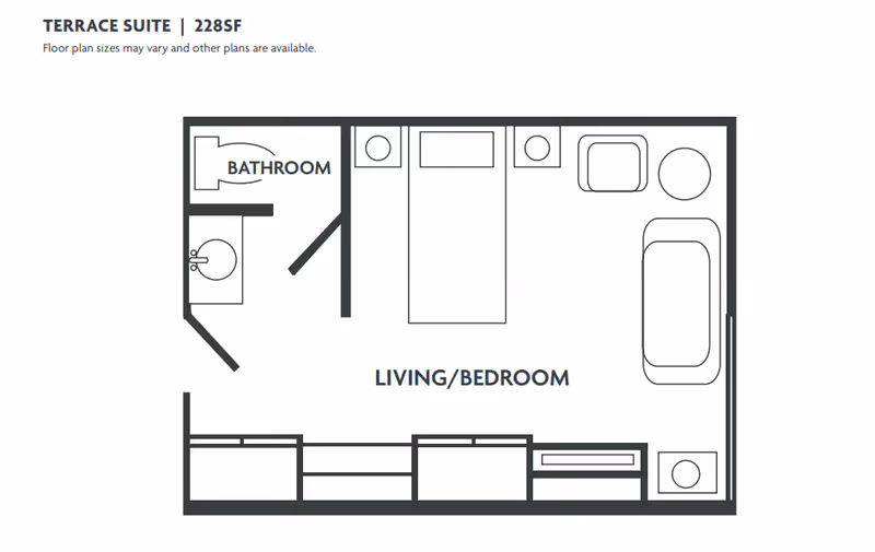 Floor plan of a Terrace Suite measuring 228 square feet, showing a combined living and bedroom area with a bed, armchair, sofa, side table, and storage units, along with a separate bathroom containing a toilet and sink.