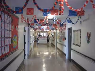 A long interior corridor decorated with red, white, and blue streamers and bulletin boards.