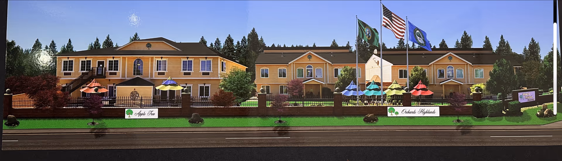 Orchards Highland senior living building exterior with flagpoles, umbrellas, and a manicured lawn.
