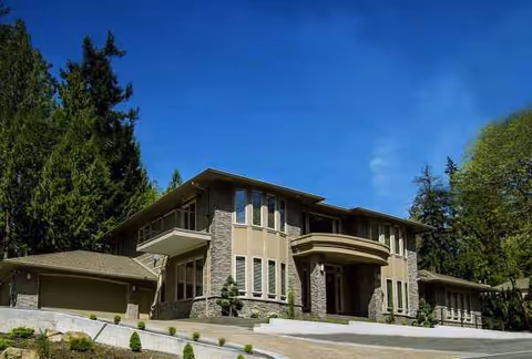 Patton Villa Senior Care building with stone exterior, curved entrance, and surrounding trees.