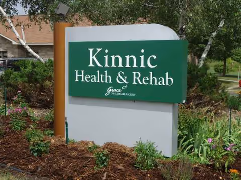 Green Kinnic Health & Rehab sign with landscaping in an outdoor area.