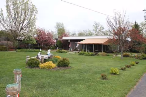 Exterior view of a nursing center with a well-kept lawn and covered entrance.