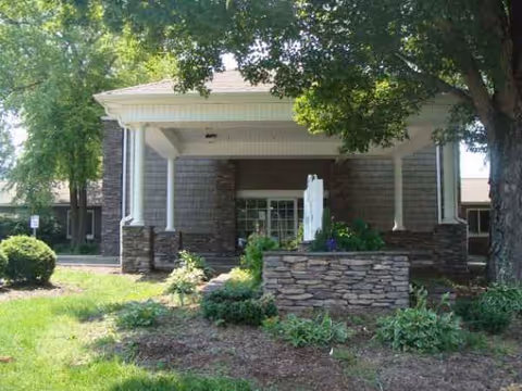 Front view of Cedar Hills Center entrance with stone columns and landscaped greenery