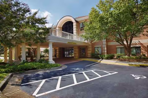 Exterior view of Independence Village of Olde Raleigh, showing the entrance and parking.