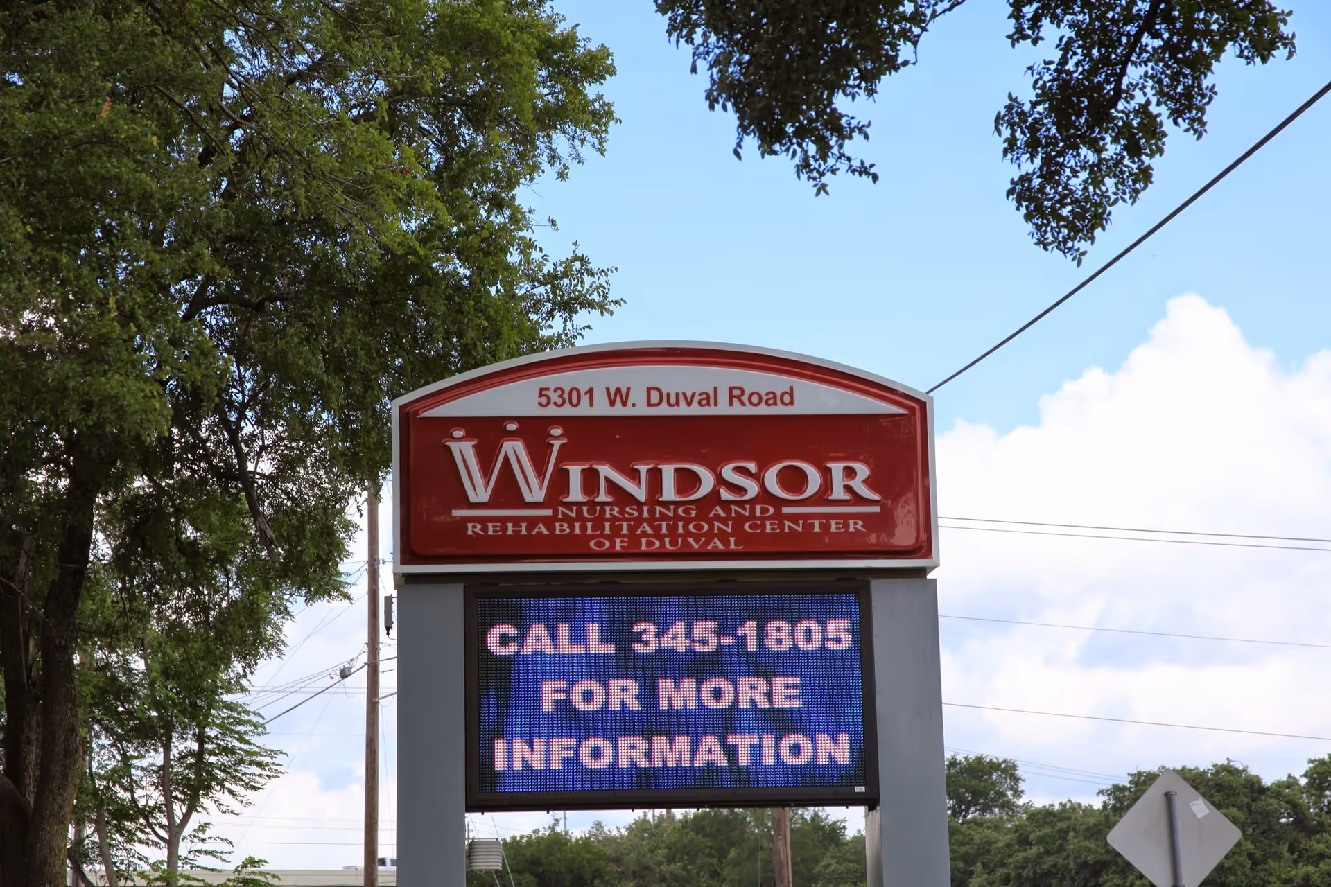 Outdoor roadside sign for Windsor Nursing and Rehabilitation Center of Duval showing the address and an electronic message board.