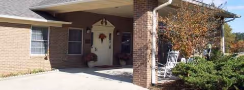 Brick exterior of Best of Care Assisted Living with a covered entrance and outdoor seating.