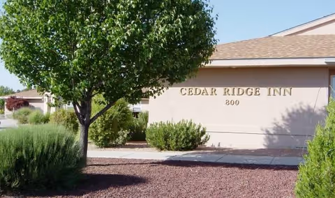 Front exterior of Cedar Ridge Inn with landscaping and building sign.