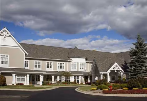 Sunrise of Troy exterior building with manicured landscaping and blue sky.