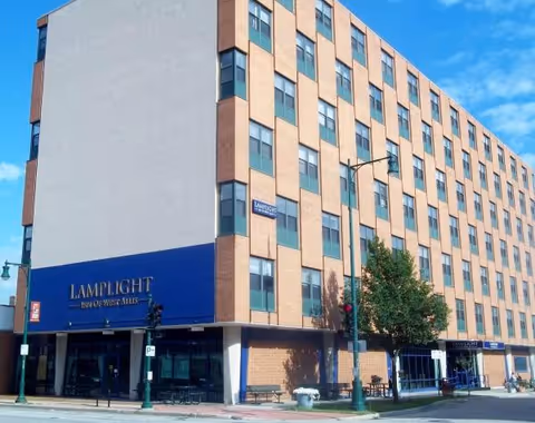 Exterior view of a brick multi-story building with a blue storefront sign.