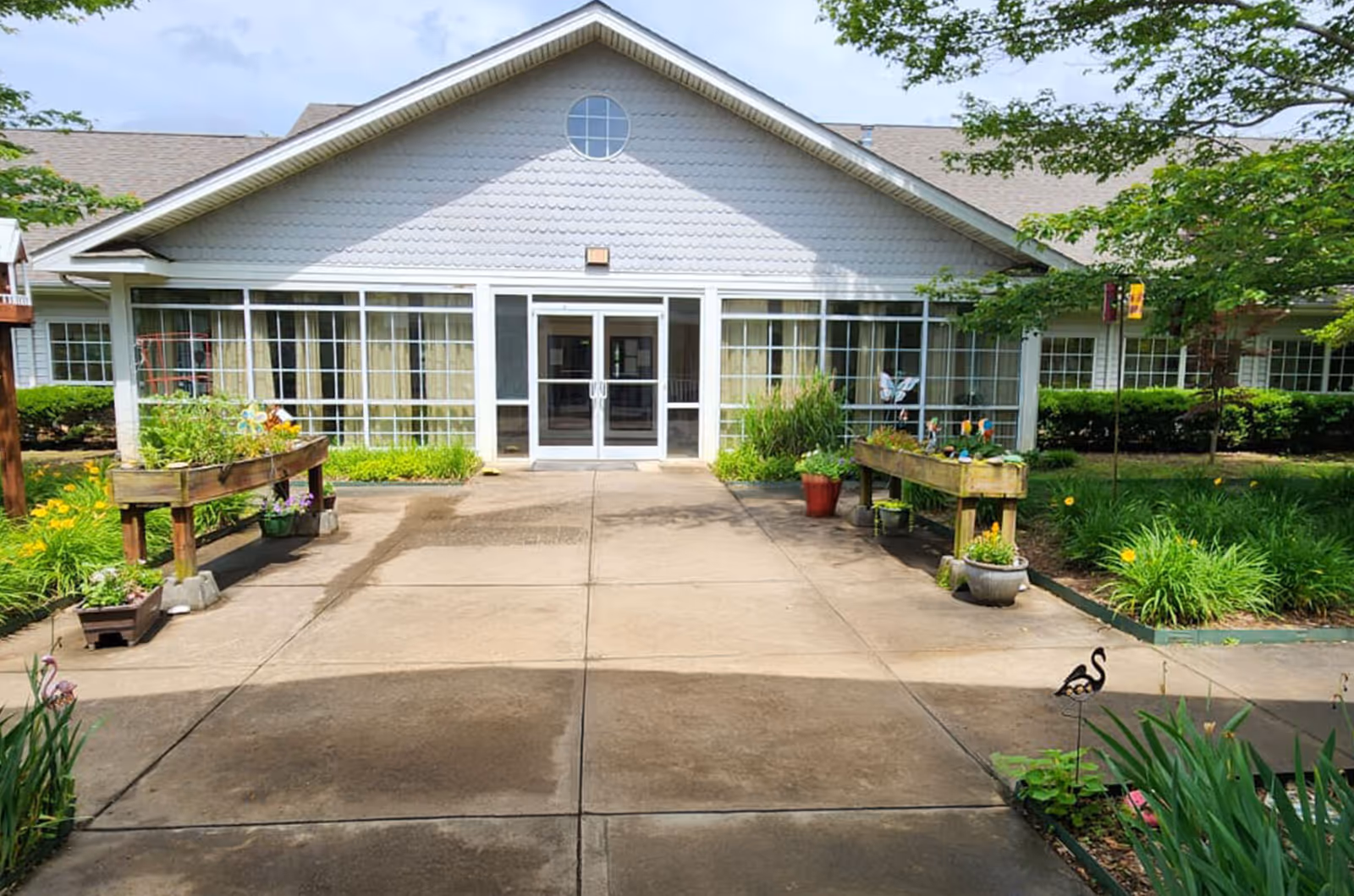 Front view of Fletcher Rehabilitation and Healthcare Center entrance with glass doors and planters.