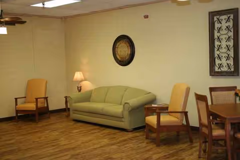 Common living area with sofa, armchairs, dining table, and warm lighting.
