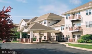 Exterior view of a multi-story senior living facility named Sherman Glen with balconies, a covered entrance, and landscaped surroundings under a clear sky.
