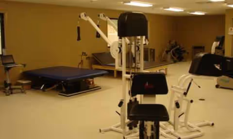 Interior rehab gym at Lakeland Nursing and Rehab with exercise machines and therapy tables.
