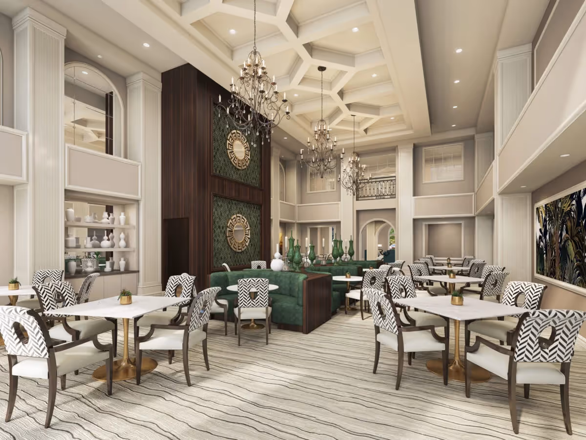 Elegant double-height dining lounge with chandeliers, round marble tables, patterned chairs and a central green banquette.