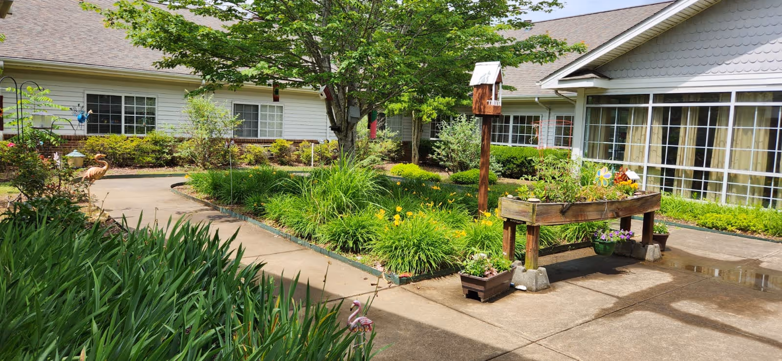 Exterior view of Fletcher Rehabilitation and Healthcare Center with a garden and walkway.