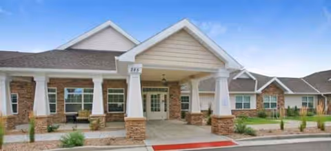 Exterior view of Brookdale Mariana Butte entrance with a covered porch and brick columns.
