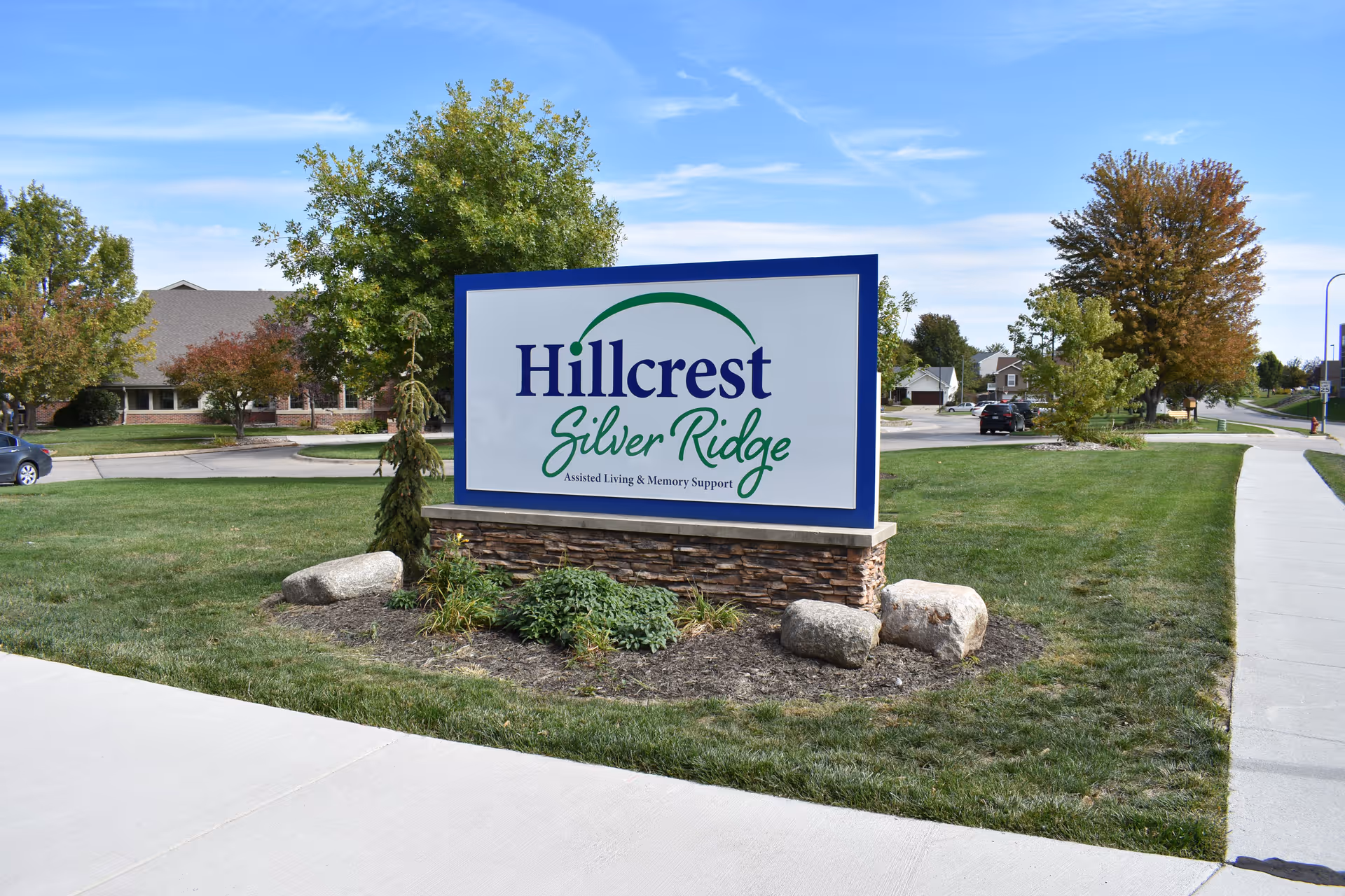 Large outdoor sign reading "Hillcrest Silver Ridge" on a stone base in a grassy area outside the facility.