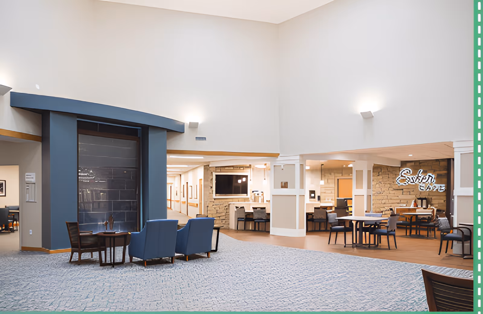 Spacious senior living common area with seating and dining tables under a high ceiling near a café/reception area.