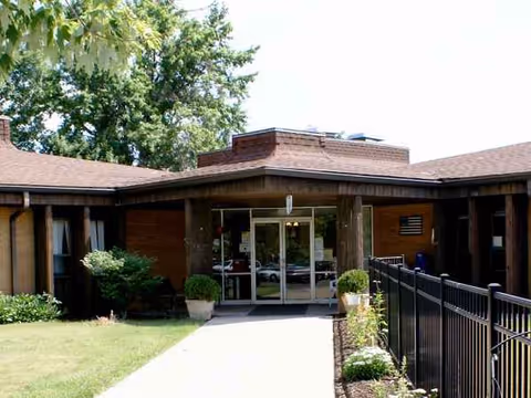 Exterior view of Crestwood Care Center entrance with glass doors and walkway.